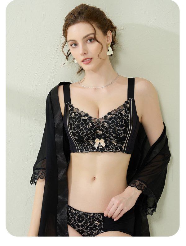 A model showcasing the elegant Mysterious Black lace push-up correction bra suit featuring gold contrast floral embroidery, fixed double shoulder straps, and matching panties,